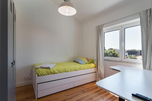 Habitación pequeña con cama y ventana en Caparica Dream Vila en Costa da Caparica