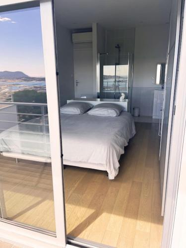 une chambre avec un lit et une grande fenêtre dans l'établissement Villa la Colombe, à Toulon