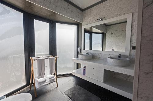 a bathroom with two sinks and two mirrors at Os Ninhos dos Avôs in Ponta Delgada