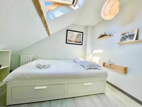 a bedroom with a bed in a attic at Pop House - Grand Jardin clos - BBQ - Spacieux & Lumineux in Saint-Nazaire