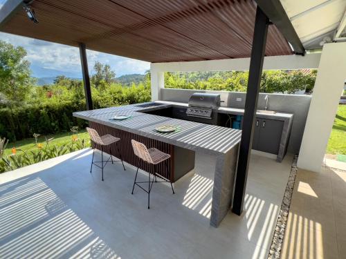 an outdoor kitchen with a table and chairs on a patio at Estudia y trabaja sin límites en Hacienda Loretto con Starlink!! in Silvania