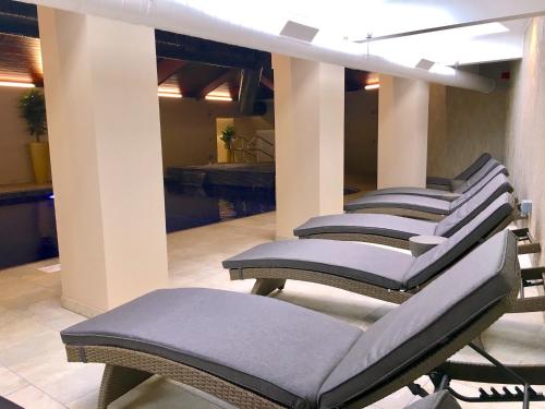 a row of chairs in front of a swimming pool at Devon Comfort Lodge with Hot Tub - Spa Resort in Devon in Chudleigh