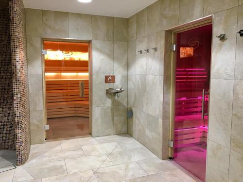 a bathroom with a walk in shower and a purple door at Devon Comfort Lodge with Hot Tub - Spa Resort in Devon in Chudleigh