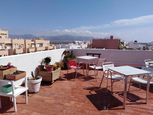 eine Terrasse mit Tischen und Stühlen auf dem Dach in der Unterkunft PAUPET in Almería