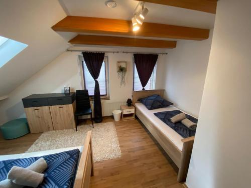 sypialnia z łóżkiem i biurkiem na poddaszu w obiekcie Ferienhaus SüMeer w mieście Wilhelmshaven