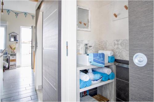 ein Badezimmer mit einem Waschbecken und Handtüchern auf einem Regal in der Unterkunft "Le Pírate benèze"gîte insolite,situation idéale,accueil attentionné in Trizay