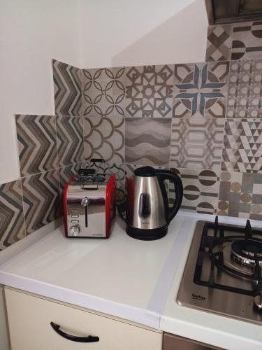un bollitore per tè e un tostapane su un bancone della cucina di casa di Angela ad Acqui Terme