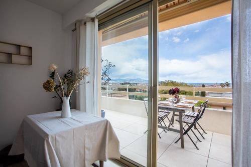 une salle à manger avec une table et un balcon avec vue dans l'établissement Vue mer, terrasse et parking privé, à Antibes