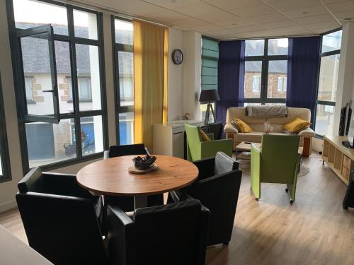 un salon avec une table, des chaises et un canapé dans l'établissement Appartement LE TRITON, à Perros-Guirec