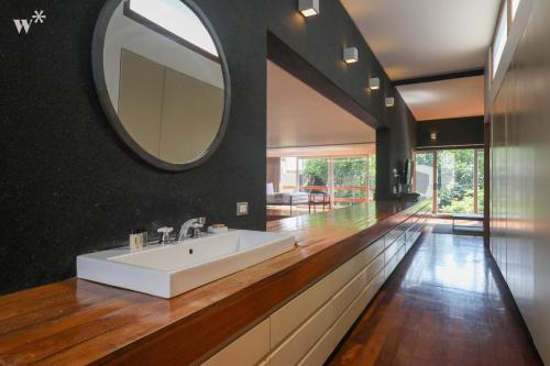 y baño con lavabo blanco y espejo. en Luxury 3BR House with Terrace in Miraflores en Lima