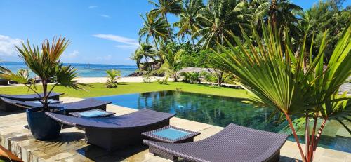 a resort with a pool and chairs and the ocean at Villa Jessivia in Afareaitu