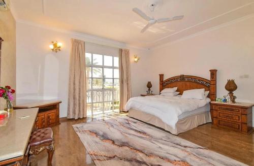 um quarto com uma cama e uma grande janela em Luxury Private Pool Villa for families only em Sanad