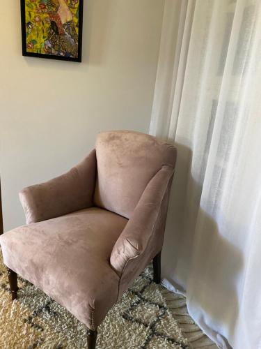 a brown chair sitting next to a window at Dar Camelia in Soûr