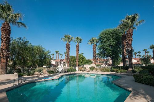 uma piscina com palmeiras num resort em Laurel Valley Lounger Permit# 068,408 em La Quinta