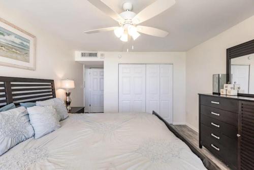 a bedroom with a large bed with a ceiling fan at Beachfront I Full Coastal Contemporary Renovation in Marco Island