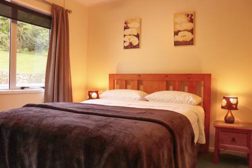 a bedroom with a large bed and a window at Al Louise Accommodation in Mangonui