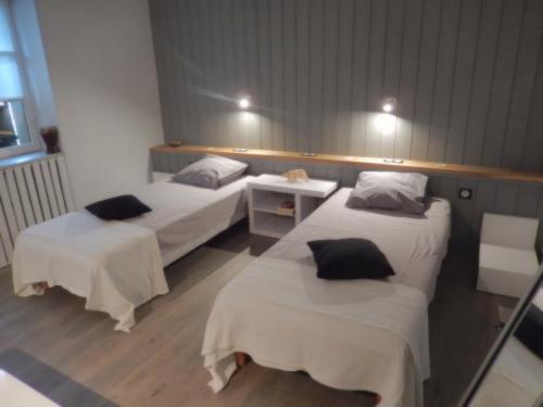 a room with two beds and a table and lights at Chambre d'hôtes à la campagne in Saint-Gence