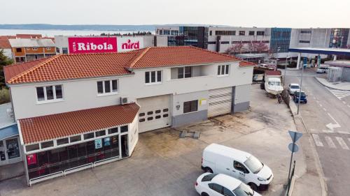 uma carrinha branca estacionada em frente a um edifício em Kapov's Rooms em Kaštela