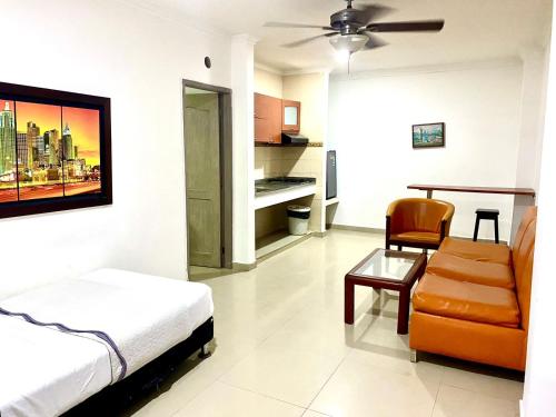 a bedroom with a bed and a chair and a table at Hotel Yivinaca in Barranquilla