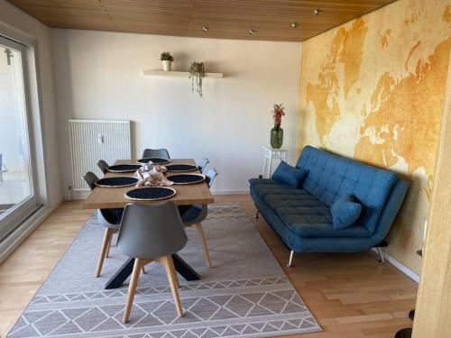 a living room with a table and a blue couch at Tolle Wohnung mit Panoramablick in Weinheim