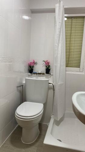 a white bathroom with a toilet and a sink at AMORE MÍO Hellín in Hellín