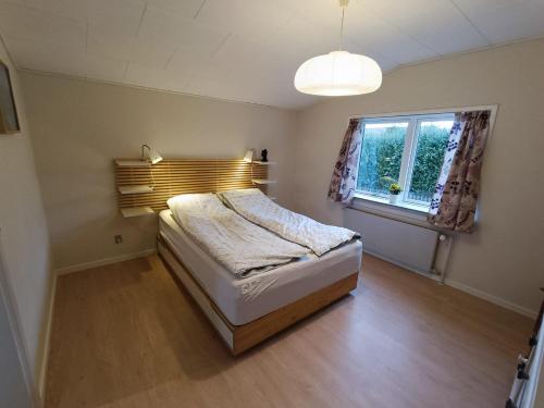 a small bedroom with a bed and a window at Svendborg, Thurø ferievilla in Svendborg