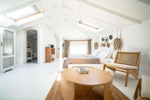 een witte kamer met een bed en een tafel bij Kurabiye Hotel in Alacati