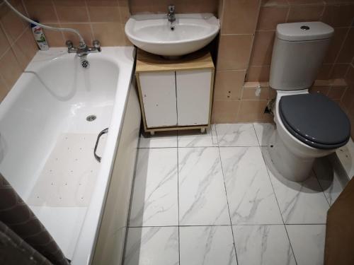 uma casa de banho com um WC, um lavatório e uma banheira em White House "Luton Airport" em Luton