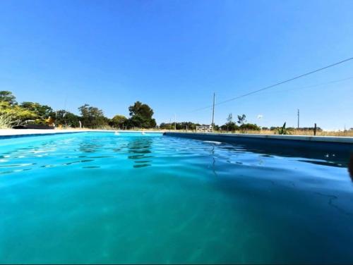 una piscina de agua azul en una carretera en Casa quinta con vista al campo en Chascomús