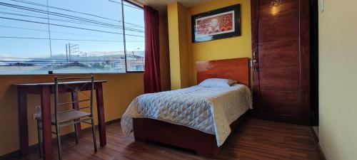 a bedroom with a bed and a large window at Hotel Caxa Wasi in Cajamarca