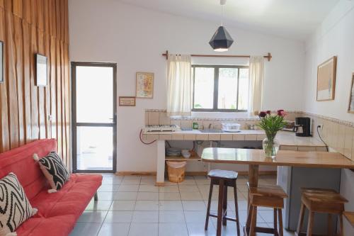 a living room with a red couch and a table at Maoritsio Garden Studios in Santa Teresa Beach