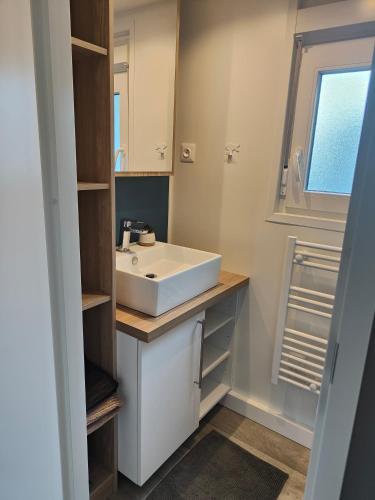 une salle de bain avec un lavabo blanc et une fenêtre dans l'établissement Le Colorful, à Dinard