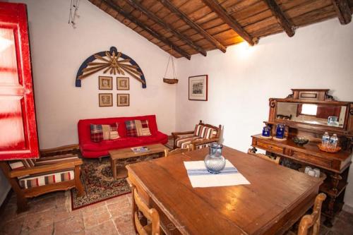 a living room with a wooden table and a red couch at Cabaña Filiberta de Lucas 