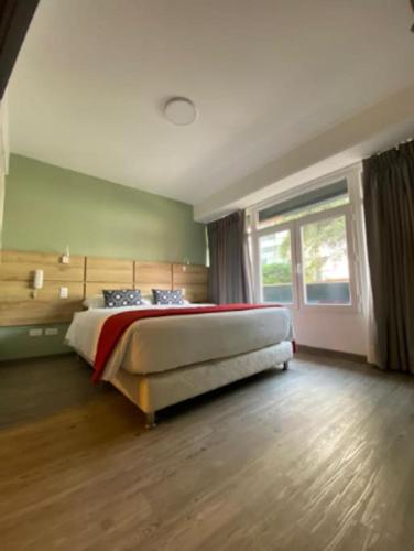 a bedroom with a bed and a large window at Serendipia Beautiful loft in San isidro 202 in Lima