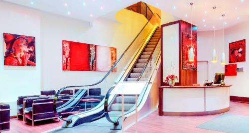 a staircase in a room with paintings on the wall at Best Western Plus Plaza Berlin Kurfürstendamm in Berlin