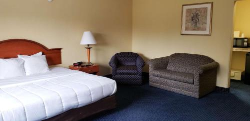 東溫莎的住宿－Motel 6 East Windsor, NJ Hightstown，配有一张床和一把椅子的酒店客房