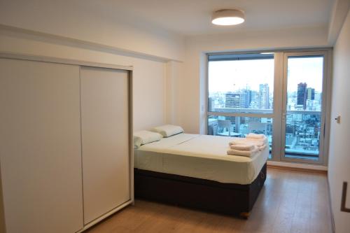 1 dormitorio con cama y ventana grande en Blue Dream Esmeralda en Buenos Aires