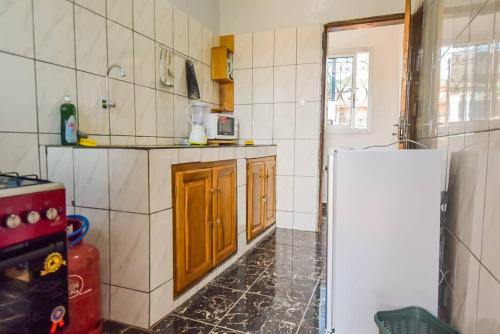 a kitchen with a white refrigerator in a room at Appartements Neuf de Haut Standing DM & NG à Bafoussam in Bafoussam