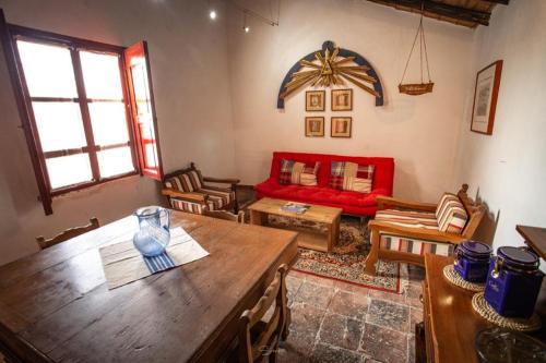 sala de estar con mesa y sofá rojo en Cabaña Corazon de Calixto, 