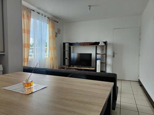 a living room with a table and a couch at Appartement T2 - Sainte-Marie - 10 min de l'aéroport in Sainte-Marie