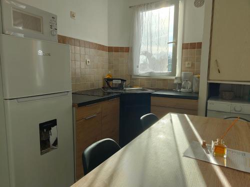 a kitchen with a refrigerator and a table with chairs at Appartement T2 - Sainte-Marie - 10 min de l'aéroport in Sainte-Marie