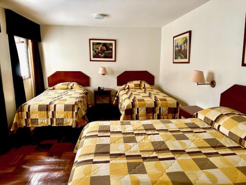 a hotel room with two beds and a window at HOTEL SAN ANDRES *** in Trujillo