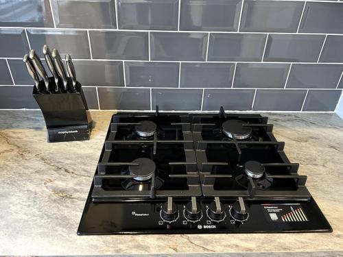 a stove top with a bunch of knives on it at Seaforth Deluxe 2 bedroom apartment at Rockman Luxury Short Stays Lets and Accommodation in Southend-on-Sea