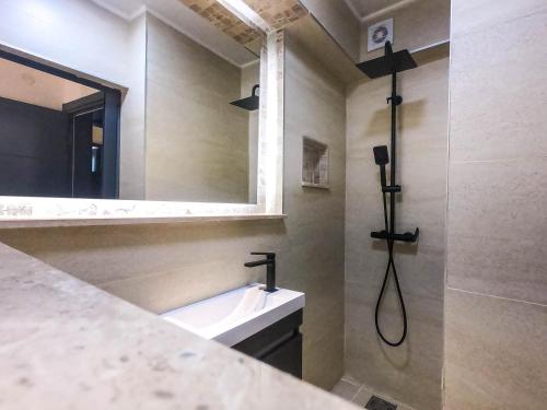 ein Bad mit einem Waschbecken und einem Spiegel in der Unterkunft Sand Apartments in Ulcinj