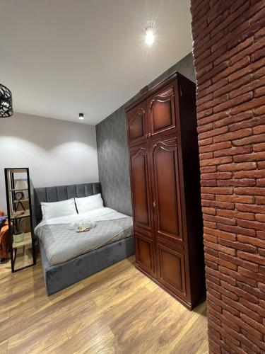 a bedroom with a bed and a wooden cabinet at Room 42 in Tbilisi City