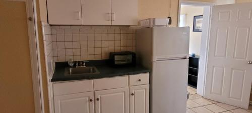 a kitchen with a white refrigerator and a sink at Stay Inn Oklahoma in Davis