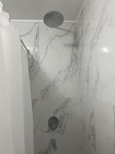 baño con ducha de mármol blanco en Monoambiente Urquiza en Buenos Aires