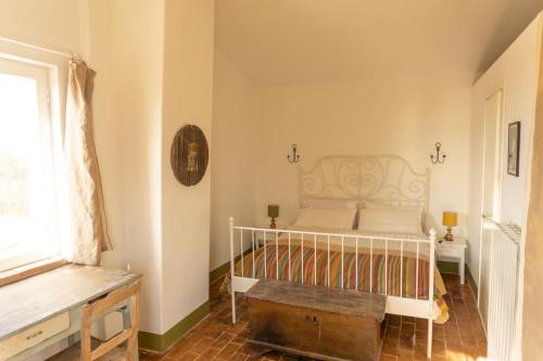 a bedroom with a bed and a window at Casale Le Pietre in Marta