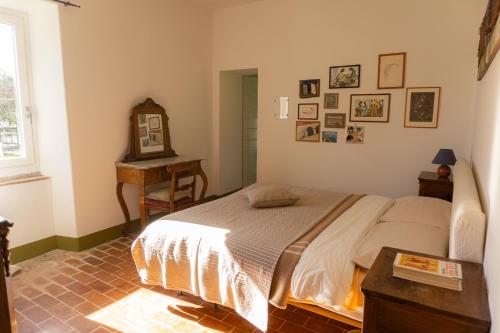a bedroom with a bed and a table and a window at Casale Le Pietre in Marta