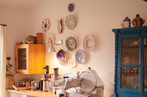 a kitchen with plates on the wall and a fan at Casale Le Pietre in Marta